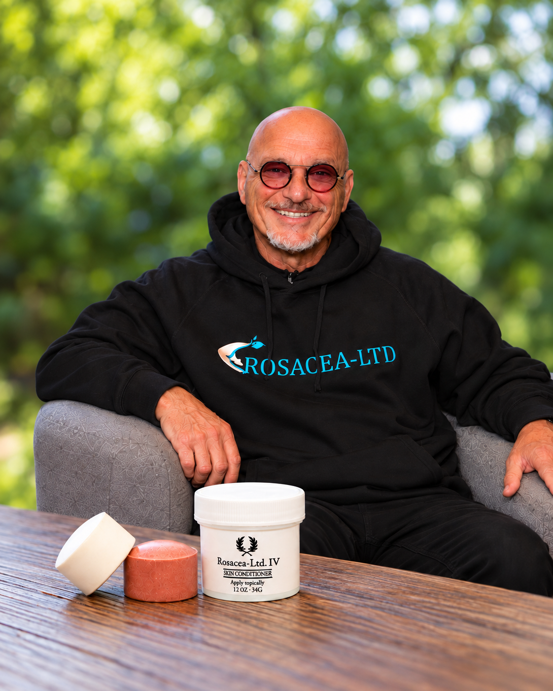 Howie Mandel sits beside Rosacea-LTD product jars in a promotional graphic for its patented mineral disc. 